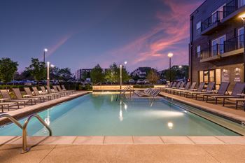A large outdoor swimming pool surrounded by lounge chairs.